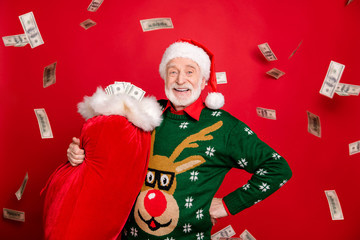 Gifts debit credit bank. Portrait of grey white hair beard old man pensioner retired rich santa claus hold bag finance deliver people in x-mas wear antler design sweater isolated red color background