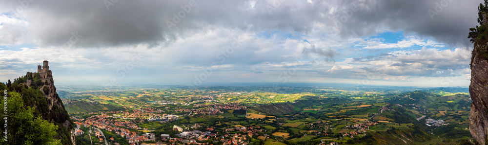 Obraz na płótnie Panoramic view of the Italian countryside and Adriatic Sea (Riviera Romagnola) from Republic of San Marino with the oldest tower (Guaita fortress) on Mount Titan (Monte Titano) on the left w salonie