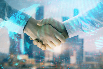 Double exposure of world map on cityscape background with two businessmen handshake. Concept of international business