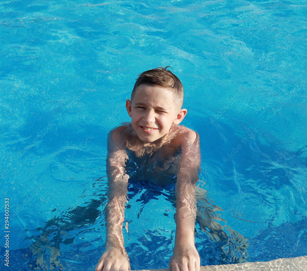 Happy cute boy in the pool on a sunny day Stock Photo | Adobe Stock
