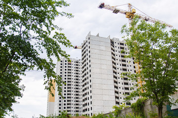 Construction of new house or building. General view. Unfinished cement building in the summer. The introduction of urbanization into nature. Capital construction in Ukraine