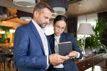 Aufkleber - Two serious colleagues in formalwear reading electronic document in touchpad