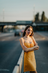 Wall Mural - A young woman stands on a background of cityscape.