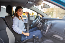 Young Girl Is Fastening Her Seat Belt. Photo Of A Business Woman Sitting In A Car Putting On Her Seat Belt.  Woman Fastening Seat Belt In The Car, Safety Concept