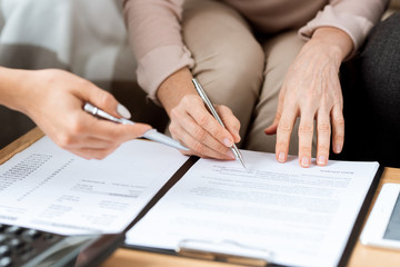 Poster - Hands of mature client and real estate agent with pens pointing at contract