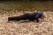 © bojanzivkovic - Middle Age Men Doing Push Ups on Rocky Ground Near River