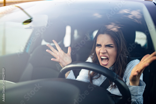 Fotografía Closeup portrait, angry young sitting woman pissed off by drivers in front of her and gesturing with hands