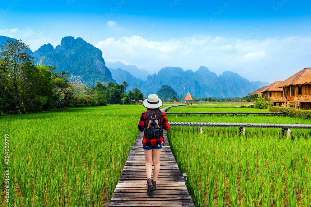 Tourism with backpack walking on wooden path, Vang vieng in Laos. - obrazy, fototapety, plakaty 