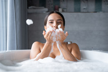 Relaxed Young Woman Taking A Bath With Foam