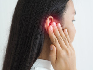 ruptured eardrum,tinnitus and meniere disease and otitis media in asian woman. She use hand touching her ear causes of ear pain on white background use for health care concept.