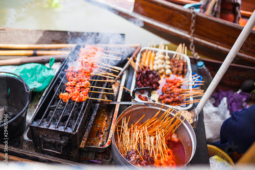 asian streedfood bbq grill in an wooden canoe on amphawa floating market in thailand on a river near bangkok Wallpaper Mural