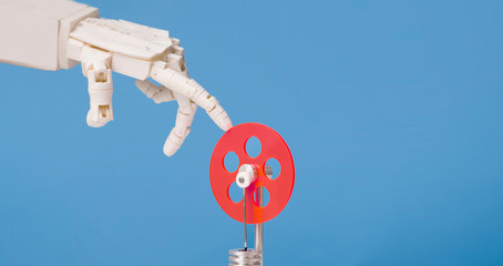 Aufkleber - Robot hand touching red plastic gear, blue background