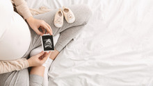 Pregnant Woman Enjoying Future Motherhood With First Ultrasound Photo