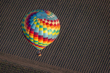A Colorful Hot Air Balloon Flies High In The Sky Early In The Morning At Sunrise Above The Napa Valley, California, Known For Its Vineyards And Wineries In Addition To Ballooning.  