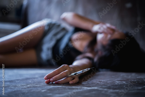 Fotomural young drug addict female on the floor with drugs in syringe on her hand