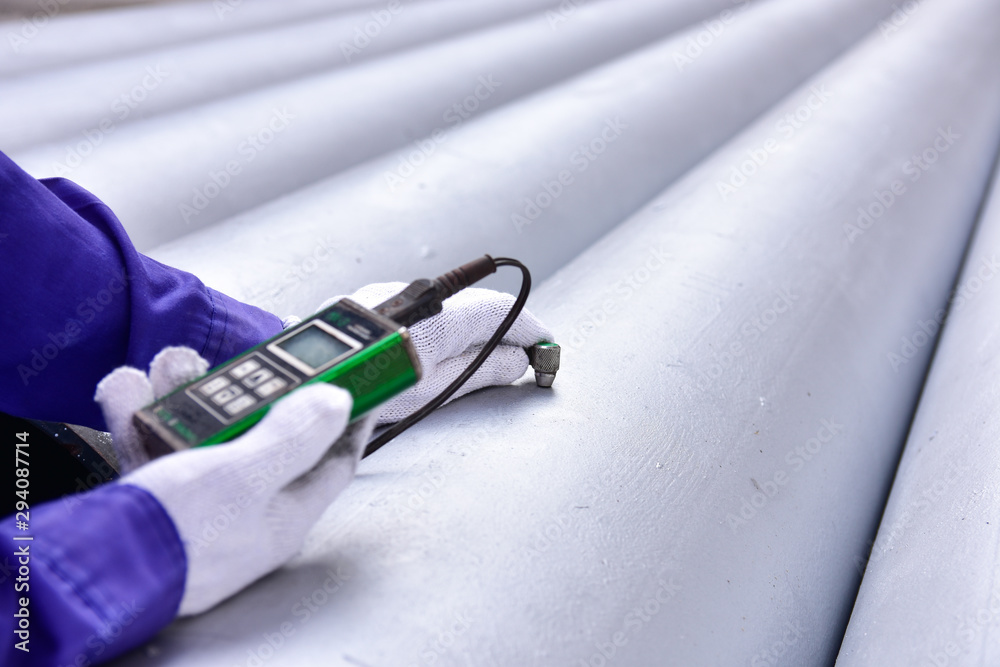 Inspector measuring thickness the pipe with UTM (Ultrasonic thickness ...