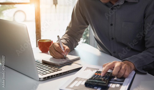 Cuadros en Lienzo Male businessman working on desk office with using a calculator to calculate the numbers, finance accounting concept