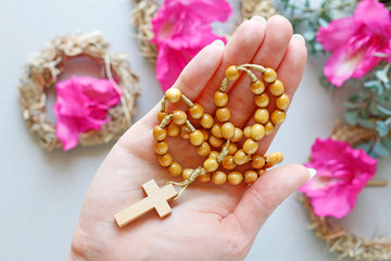 Wall Mural - Woman holds wooden rosary in her hand