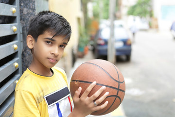 Wall Mural - Portrait of Indian boy holding basketball