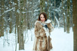 © shabbydatwin - Beautiful young woman in furs. Snowy winter forest background.