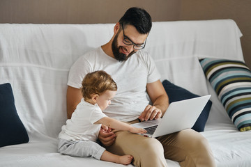 young smiling man in glasses teaching his kid to work on laptop, education, leisure, pastime , close