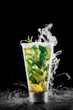 Cocktail with lemon, mint, rum and dry ice with smoke effect on the black background