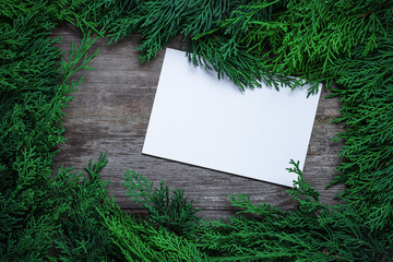 Wall Mural - Christmas green frame from fir branches on a vintage gray board background. Frame of fir branches. Christmas card blank.