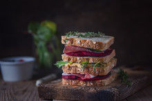Sandwich With Prosciutto, Beetroot, Salad Mix On A Wooden Background