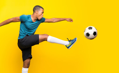 Wall Mural - Afro American football player man over isolated yellow background