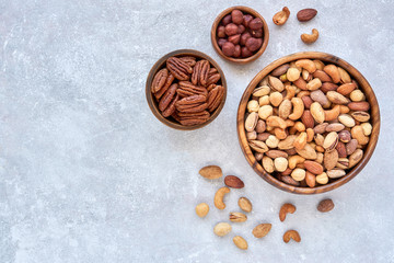 Wall Mural - Roasted salted mixed nuts in wooden bowls. Top view with space for text