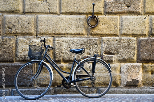 Dekoracja na wymiar  czarny-rower-oparty-o-kamienna-sciane-starozytnego-budynku-ze-starym-zardzewialym-zelazem