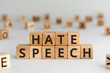 © SecondSide - Hate speech - words from wooden blocks with letters, speech that attacks a basis attributes such as race, religion, gender identity hate speech concept, random letters around, white  background