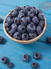 Wall Mural - Raw fresh huckleberry in a bowl. Wooden background.