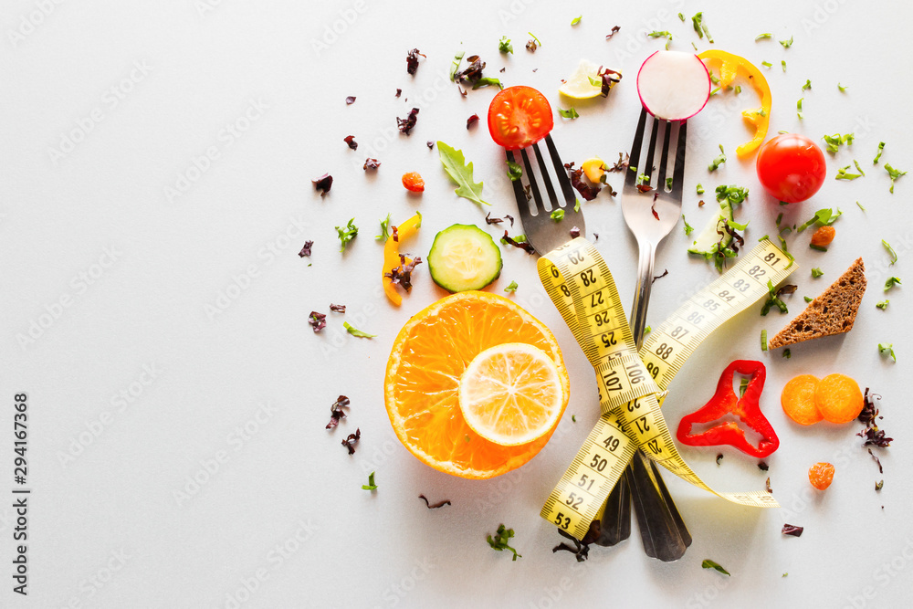 vegetables on forks with measuring tape on a white background with place for text. concept diet, weight loss, fat loss - obrazy, fototapety, plakaty 