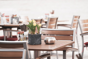 Wall Mural - Street view with cafe terrace during the morning in European city