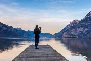 Canvas Print - A woman photographs an evening landscape in the mountains.