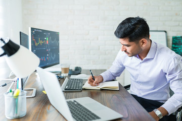 Wall Mural - handsome latin trading freelancer working from home