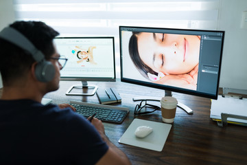 Wall Mural - Male Freelance Editor Looking At Computer