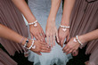 Four woman's hand with heart bracelet