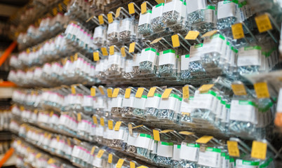 Canvas Print - Rows of boxes with bolts in hardware store closeup