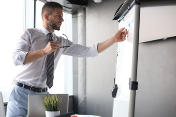 Wall Mural - Modern businessman is using flipchart in the office