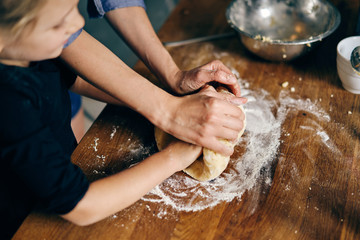 Mother and daughter cooking holiday cookies in winter season at home