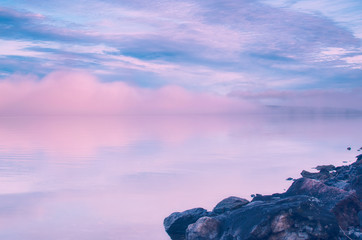 Wall Mural - Long Exposure of Sunset at the Paijanne lake. Beautiful scape with stone beach, fog and water. Lake Paijanne, Finland.