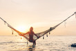 © Alena Ozerova - Girl relaxing in hammock on sunset beach