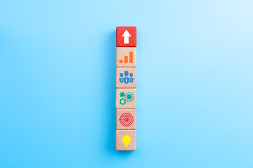 Business development strategy and Action plan concept, wooden blocks with business process management icons and arrow up on blue background, copy space