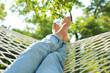 © New Africa - Young woman resting in comfortable hammock at green garden, closeup