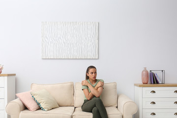 Poster - Young woman freezing under air conditioner at home