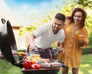 Canvas Print - Young man and woman with drinks near barbecue grill outdoors