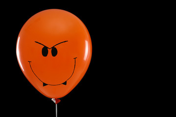 Spooky balloon for Halloween party on black background, space for text