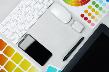 Flat lay composition with digital devices and color palettes on white background, space for text. Graphic designer's workplace